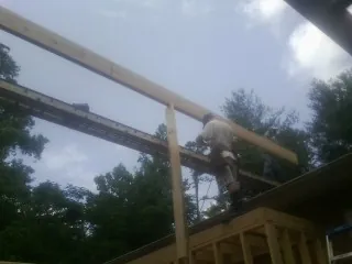 Carpenter setting a ridge beam over a new addition frame — Ice Dam Removal by Roofing Brothers in Barnhart