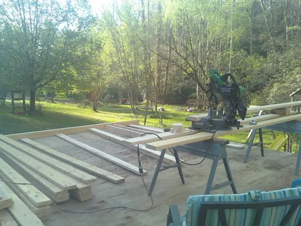 Miter saw and framing lumber on a deck under construction in Barnhart