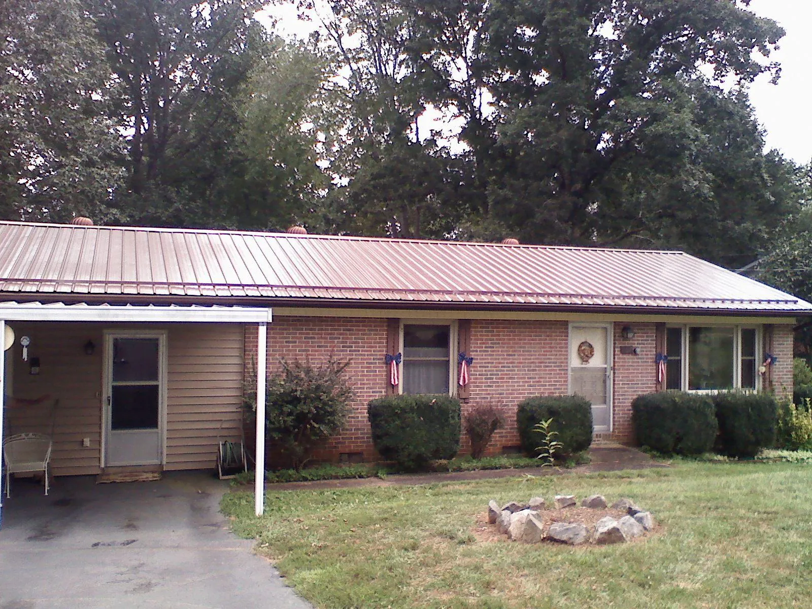 Bronze metal roof and carport on a brick ranch home — Roof Repair work by our crew in Barnhart
